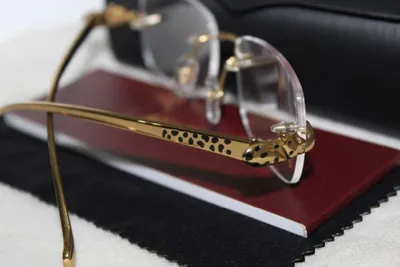 Patilla dorada de un armazón Cartier al aire con la pantera de manchas negras