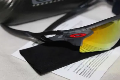 Detalle de unos lentes deportivos Oakley con la O roja en la patilla
