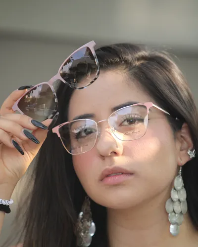 Mujer con armazón rosa y lentes de sol en la cabeza