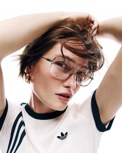 Mujer con armazón oftálmico adidas Originals y playera con el trébol