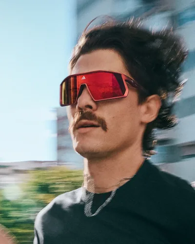 Hombre con lentes deportivos adidas de mica roja espejeada