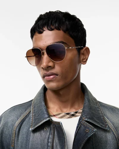Hombre con lentes de sol Burberry de aviador y chamarra de mezclilla