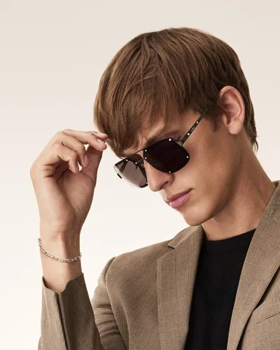 Hombre ajustándose unos lentes de sol Cartier