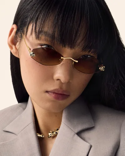 Mujer con lentes de sol Cartier metálicos con la pantera en las patillas