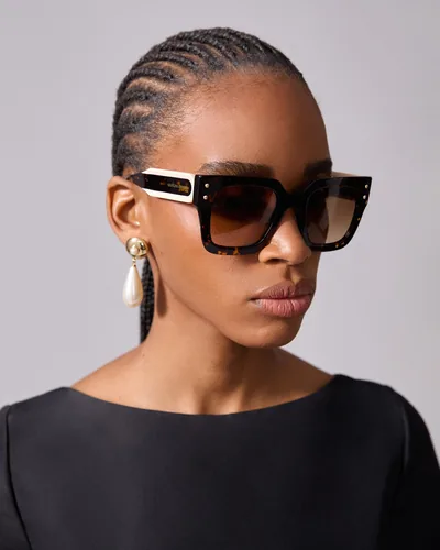 Mujer con lentes de sol Carolina Herrera negros cuadrados