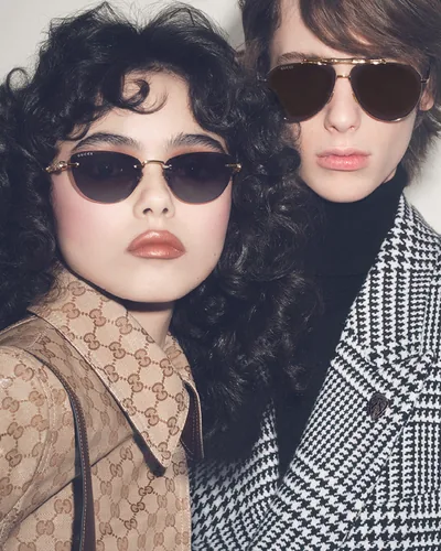 Pareja con lentes de sol Gucci, ella redondos y él de aviador