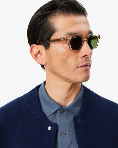 Hombre con lentes de sol Lacoste de acetato claro con micas verdes