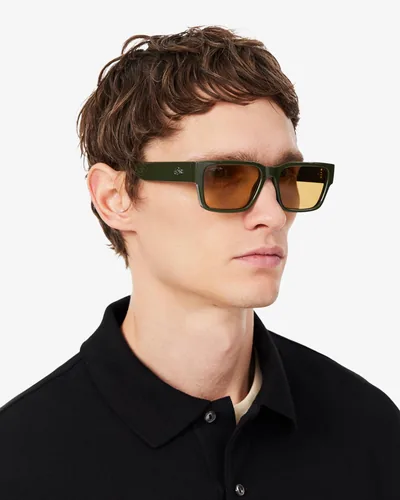 Hombre con lentes de sol Lacoste verde olivo con micas ámbar