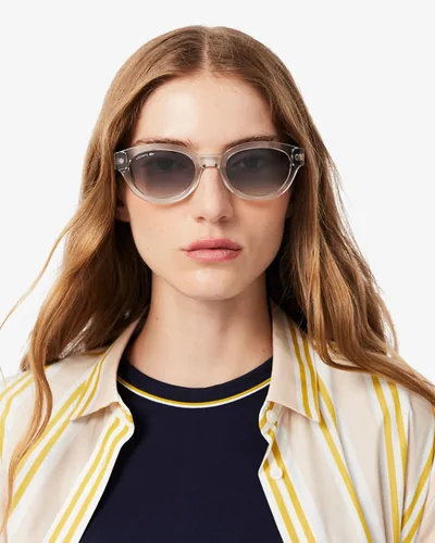 Mujer con lentes de sol Lacoste transparentes de ojo de gato