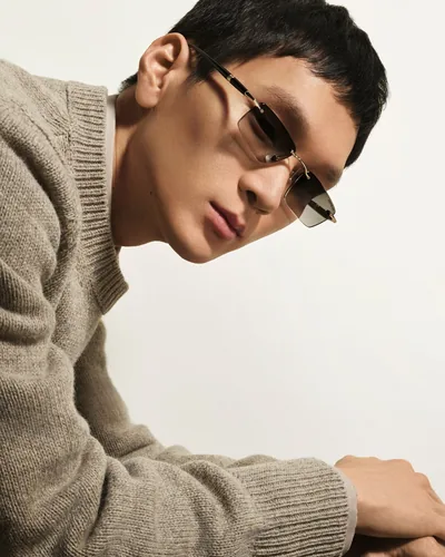 Hombre con suéter y lentes de sol Montblanc metálicos dorados