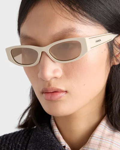 Mujer con lentes de sol Prada color marfil de ojo de gato