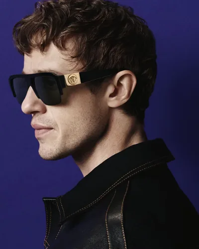 Hombre con lentes de sol Versace negros con la Medusa dorada
