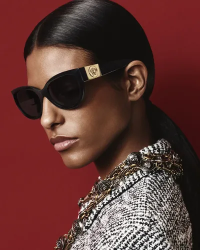Mujer con lentes de sol Versace negros con la Medusa dorada