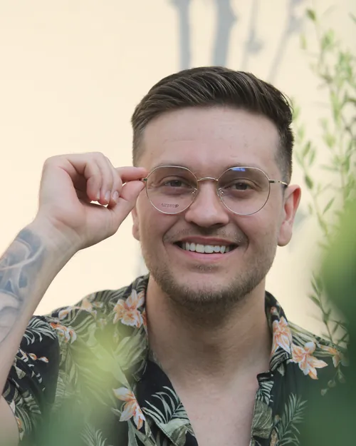 Hombre sonriendo con lentes graduados de armazón metálico