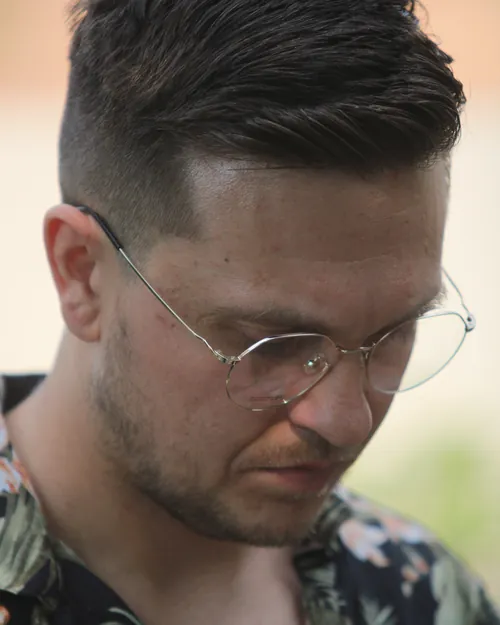 Hombre leyendo con lentes de armazón metálico