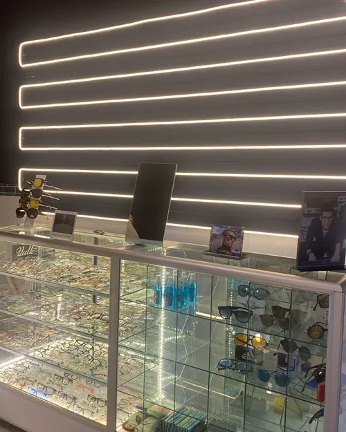 Vitrina iluminada con armazones graduados y lentes de sol en Óptica Órama